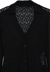Cardigan in pizzo nero con scollo a V, chiusura con bottoni, maniche lunghe e intricate fantasie floreali su tutta la stoffa.