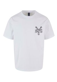 Hvid bomulds t-shirt med et sølvfarvet dødningshoved og korslagte knogler grafik på venstre bryst. Rund halsudskæring og korte ærmer.