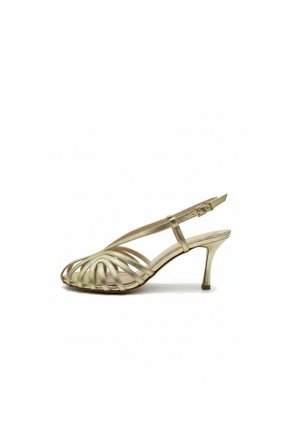 Sandalo slingback dorato con punta aperta, design a listini e tacco sottile di media altezza su sfondo bianco.