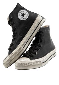 Czarne trampki wysokie z płótna o teksturowanym wykończeniu, gumowe podeszwy, białe akcenty oraz okrągłe logo na kostce.