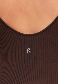 Body marron côtelé avec un décolleté profond en forme de scoop ; orné d'un logo "R" argenté près de l'encolure. Texture lisse avec une coupe ajustée.