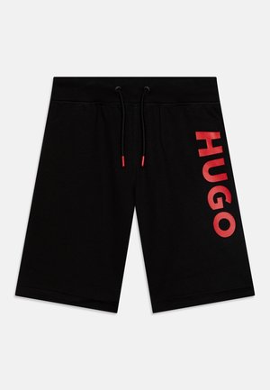 Zwarte knielange shorts met elastische tailleband, zwarte trekkoorden met rode uiteinden en een gedurfde rode verticale "HUGO"-tekst op het rechterbeen.