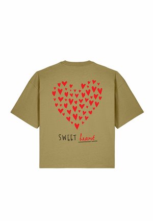 Übergroßes beiges T-Shirt mit roten Herzen, die eine große Herzform bilden, und den Worten "SWEET heart" unten in Schwarz und Rot gedruckt.
