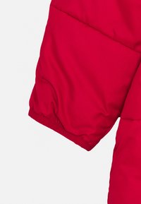 Rode pufferjacketslaap, met een gequilt patroon, licht toelopend ontwerp en elastische manchetten voor een comfortabele pasvorm.