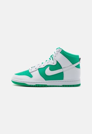 Sneaker alta bianca e verde con lacci bianchi, punta perforata e logo Nike swoosh sul lato, mostrata su sfondo bianco.