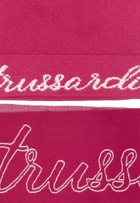 Fuchsia textiel met gedurfde witte letters "trussardi" en "truss" in een vloeiende schrijfwijze, met een zachte, gladde textuur.