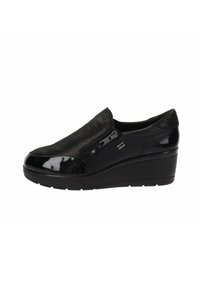 Scarpa nera slip-on con punta in vernice liscia, parte superiore testurizzata e tacco a zeppa per una maggiore altezza, dotata di cerniera laterale per una facile vestibilità.