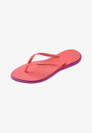 Różowo-fioletowa klapka na płaskim obcasie z teksturowaną wkładką i cienkimi paskami, z małym logo "Havaianas" na pasku.
