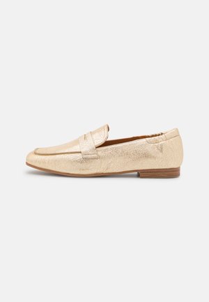 Mocasín de cuero dorado metálico con tira estilo penny, tacón bajo de madera y punta ligeramente puntiaguda, mostrado de perfil sobre fondo blanco.