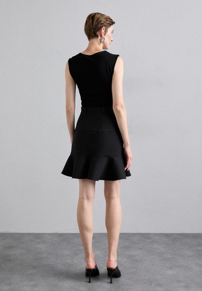 Un haut ajusté noir à manches courtes associé à une jupe évasée noire. L'ensemble présente une texture lisse et une silhouette structurée.