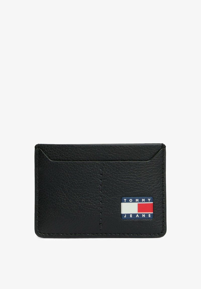 Porta carte in pelle nera con finitura testurizzata, caratterizzato da una patch con logo in blu, rosso e bianco. Include due scomparti per carte e bordi cuciti.