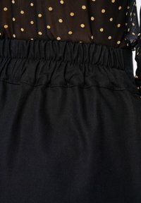 Zwarte, samengestelde tailleband met een gerimpelde rand, gecombineerd met een doorschijnende zwarte stof met gouden stippen. Eenvoudige textuur en casual ontwerp.