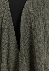 Przesadnie duży, otwarty kardigan w teksturowanym oliwkowym splocie, z głębokim dekoltem w kształcie V i subtelnym pionowym prążkowaniem.