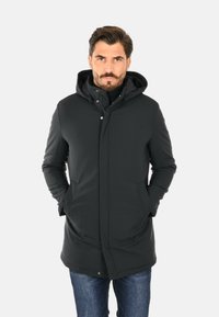 Giacca parka nera con cappuccio, dotata di chiusura a zip e bottoni a pressione, due tasche laterali e una linea dritta. Tessuto esterno morbido.