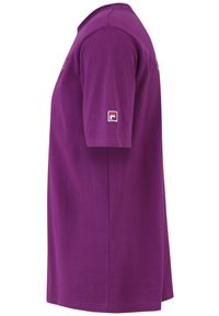Lilla bomulds t-shirt med korte ærmer og lige snit. Har et lille Fila-logo på venstre ærme. Materialet har en glat tekstur.