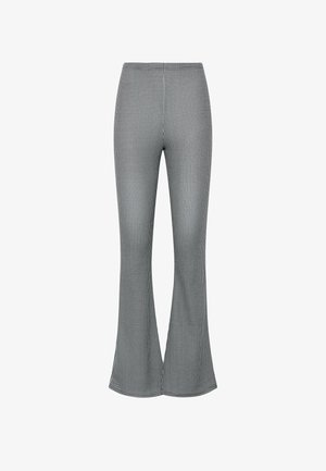 Schwarz-weiße, hoch taillierte ausgestellte Hose mit Hahnentrittmuster, eng anliegend an den Oberschenkeln und mit weiteren Beinöffnungen.