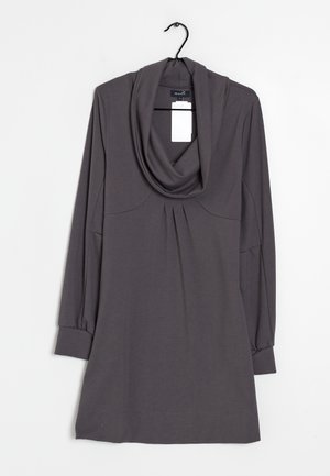 Robe grise à manches longues avec un col drapé, des détails plissés à l'avant et des poignets ajustés. Fabriquée dans un tissu doux, elle comporte une étiquette fixée près du col.