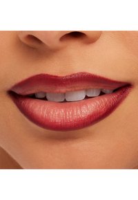 Nærbilde av lepper med en dyp burgunder leppefarge og subtil glans. Overleppen har en tydelig form, med synlig tekstur og glatthet.