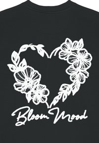 Felpa nera con un design floreale a forma di cuore bianco e la scritta "Bloom Mood" in stile calligrafico.