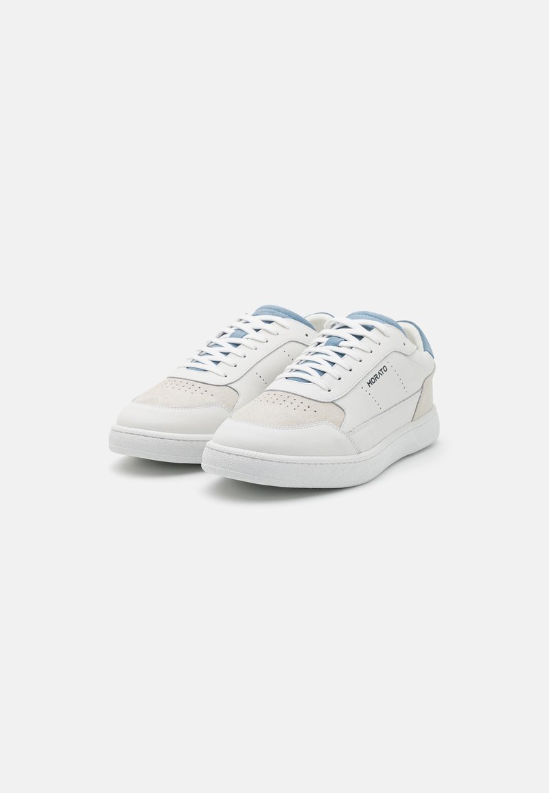 Sneaker bianchi in pelle con dettagli azzurri chiari, perforazioni decorative, lacci piatti e suola in gomma bianca texture. Design della punta arrotondata.