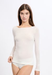 Langærmet t-shirt med rund hals i lys beige, lavet af blødt, gennemsigtigt stof. Har et tætsiddende design og en enkel, sømløs silhuet.