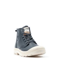 Zapatillas altas en material sintético azul marino, con suela de goma texturizada y acentos blancos. Cuenta con cordones oscuros y parche con el logo en la lengua.