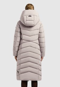 Svetlo šedý péřový kabát s chevronovým vzorem, ktorý má veľkú kapucňu, dlhé rukávy a trojuholníkovú značku na dolnej strane.
