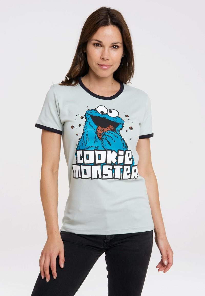 Light blue t-shirt with a black ringer collar featuring a graphic of Cookie Monster and the text "cookie monster" in bold white letters.
