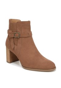 Braune Wildlederstiefelette mit einem gestapelten Absatz, ausgestattet mit einer seitlichen Schnalle und Riemendetails. Glatte Textur und spitzes Design.