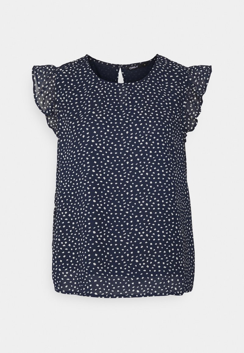 Blouse bleu marine avec des pois blancs irréguliers, manches courtes en voile à volants, encolure ronde et détail d'œillet avec bouton au dos.