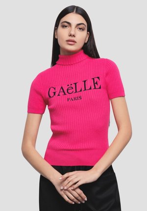 Top aderente a maniche corte in maglia a coste di un vivace rosa con scollatura alta. Presenta il testo nero "GAËLLE PARIS" sul fronte.