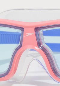 Zwemgoggles met een roze frame en heldere, blauw-getinte lenzen; heeft een gebogen vorm, zachte siliconen randen en een gestroomlijnd ontwerp.
