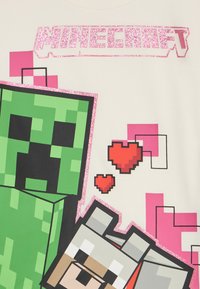 Logo Minecraft en paillettes roses au-dessus d'un Creeper vert pixélisé et d'un loup gris avec deux cœurs rouges pixélisés sur fond blanc.