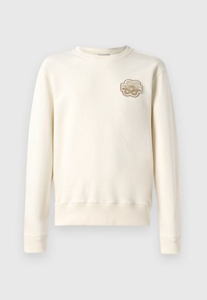Felpa beige chiaro con collo tondo, maniche lunghe e polsini a coste. Presenta un patch ricamato decorativo sul lato sinistro del petto.