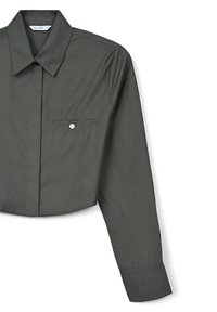 Camicia verde scuro a maniche lunghe, realizzata in tessuto morbido. Presenta un colletto a punta, maniche lunghe e una tasca sul petto con bottone.