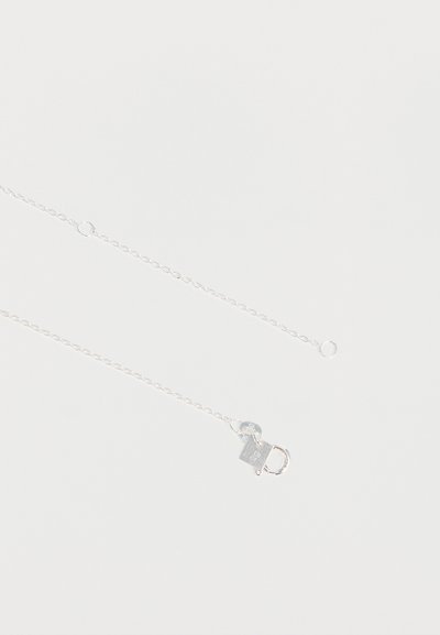 Collier délicat en chaîne d'argent avec un petit fermoir rectangulaire marqué "925" sur un fond blanc uni.