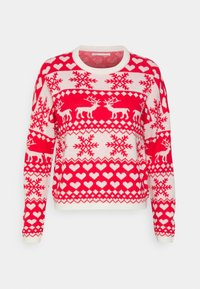Röd och vit stickad tröja med renar, snöflingor och hjärt-mönster. Rund hals, långa ärmar och texturerad tyg.