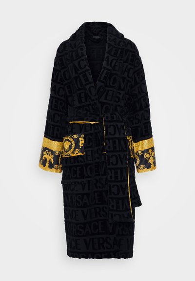 Melnā plīša jaka ar tonālajiem "VERSACE" zīmoliem, zelta akcentiem uz piedurknēm un kabatas, kā arī jostu aizdarēšanai.