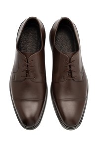 Scarpe eleganti in pelle marrone con finitura liscia, punta arrotondata e lacci sottili. Presentano una cucitura a sbieco e una soletta testurizzata.