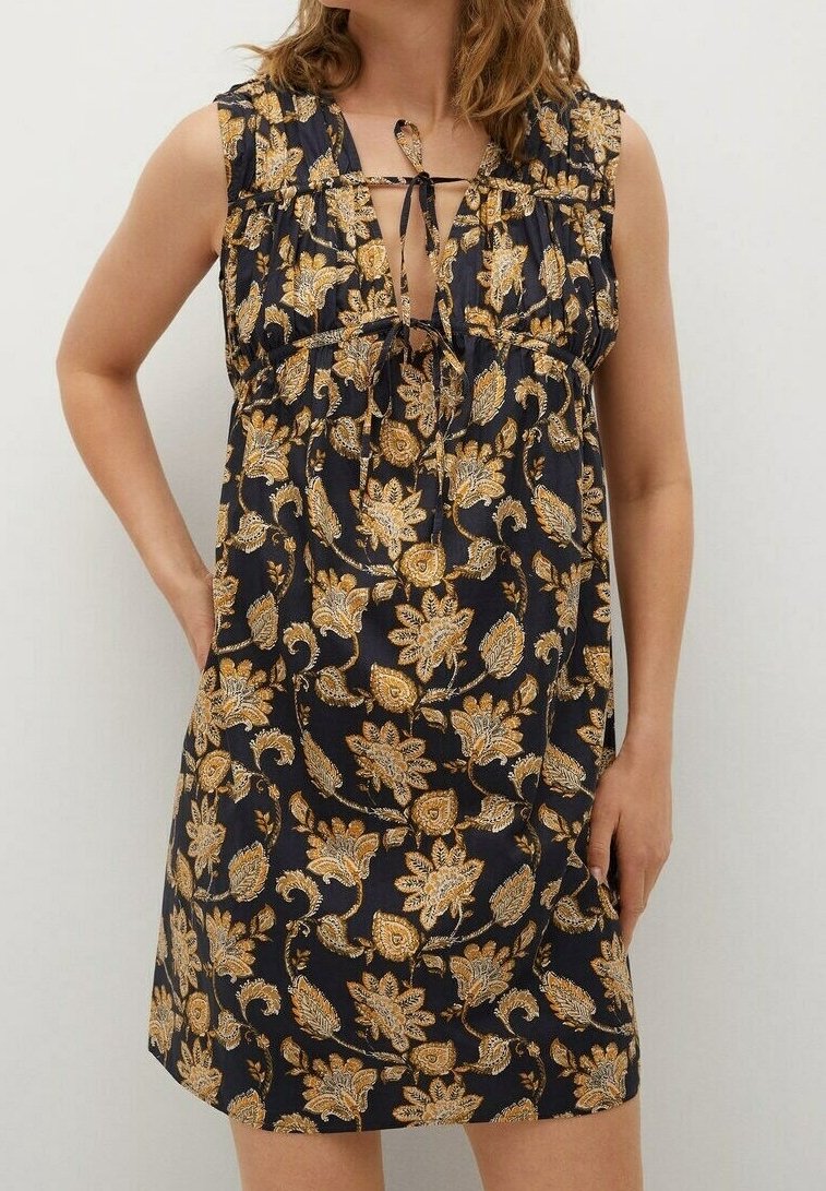 Robe noire à motif floral en tissu léger, ornée de motifs paisley dorés et crème, avec des manches courtes et un détail à nouer au niveau du col.