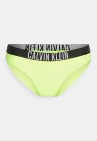 Neon gele bikini onderkant met een zwarte tailleband waarop het "Calvin Klein" logo in het wit is afgebeeld. Zachte textuur, minimalistisch ontwerp.