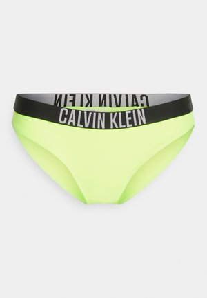 Neon-gelber Bikini-Slip mit schwarzem Bund, der das weiße "Calvin Klein"-Logo trägt. Glatte Textur, minimalistisches Design.