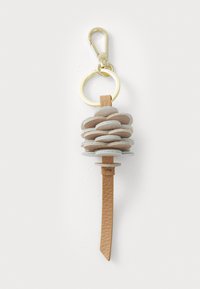 Keychain made of layered light-colored leather discs, featuring a tan leather strap and gold-colored metal clasp and ring.