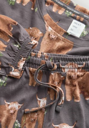 Bruin patroon pyjamaset met Schotse hooglanders, gemaakt van zacht materiaal. Voorzien van een elastische tailleband met trekkoord en bloemrijke accenten.