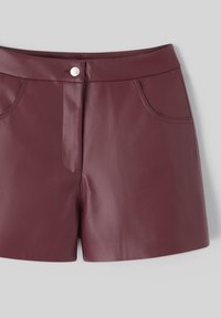 Shorts en cuir bordeaux avec une texture lisse, dotés de poches avant, d'une couture centrale et d'une fermeture à pression en métal à la taille.