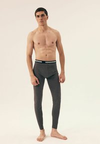 Gray long underwear made of a soft fabric, featuring a black waistband with "HENDERSON" printed in white, fitted design, and tapered legs.