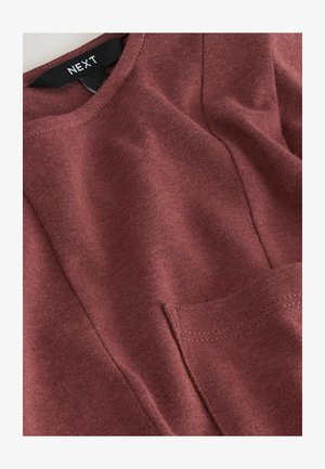 Veinipunane puuvillane pluus ümarate kaelusega, millel on rinnatasku, tekstuurse kangaga ja nähtavate õmblustega.