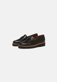Mocasines de cuero negro con un acabado suave, que presentan un acento trenzado en el empeine, una suela de contraste marrón y un interior acolchado.