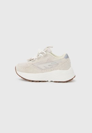 Beige sneakers med mesh og ruskindsoverdel, der har en hvid mellemsål, brune gummisåler og kontrasterende grå detaljer på hælen.