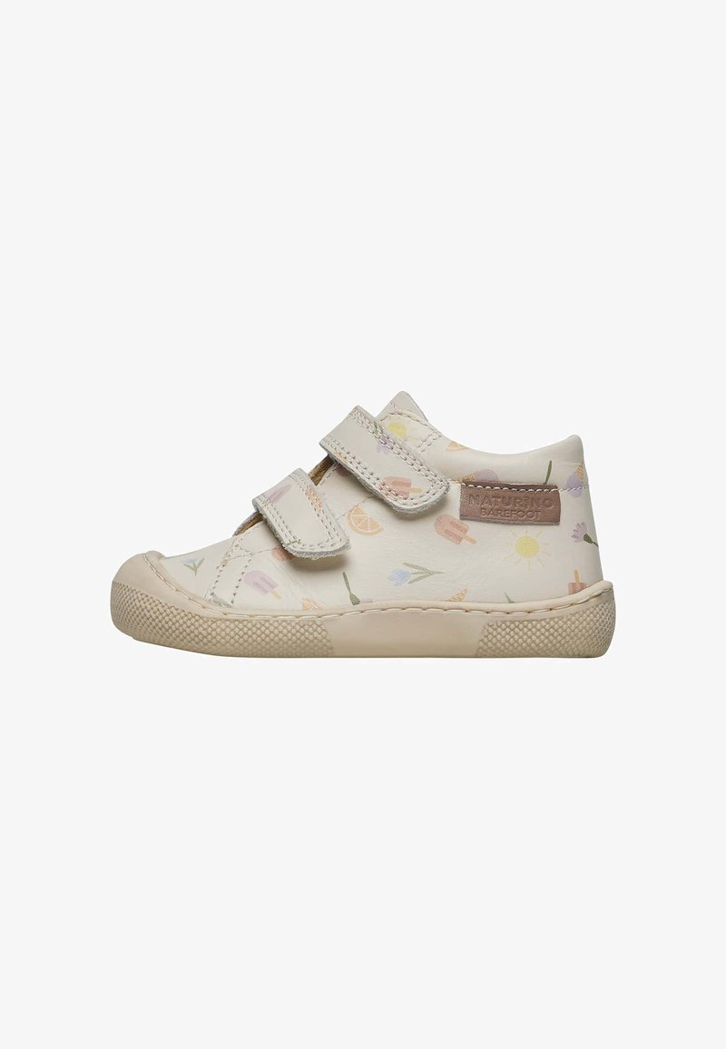 Chaussure en cuir couleur crème avec des motifs floraux pastel, un bout rond et deux bandes Velcro. Semelle en caoutchouc texturé pour une meilleure adhérence.